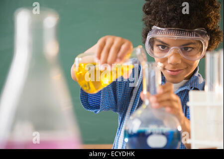 Mixed race boy experimenting in classroom science lab Stock Photo