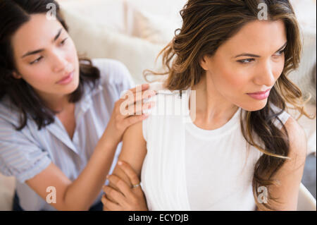 Hispanic woman comforting angry friend Stock Photo