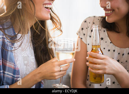 Hispanic women drinking beer and wine together Stock Photo
