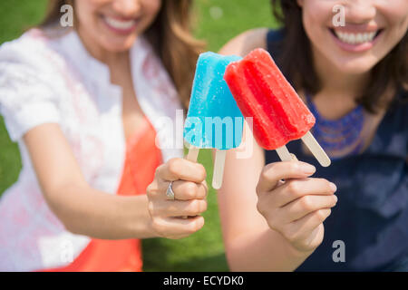 Hispanic women eating popsicles outdoors Stock Photo
