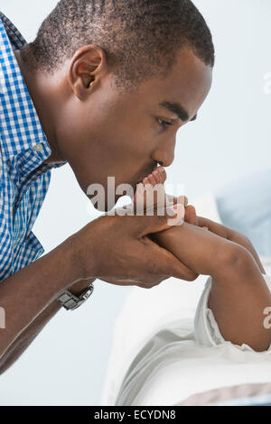 Father kissing feet of baby son Stock Photo