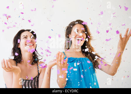 Hispanic women throwing confetti at party Stock Photo
