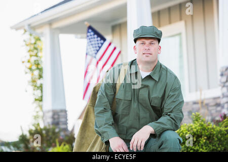 Caucasian soldier kneeling near house Stock Photo