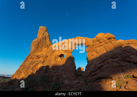 Low angle view of Turret Arch rock formation under blue sky, Arches National Park, Utah, United States Stock Photo