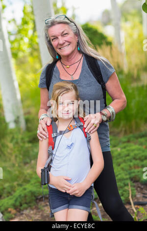 Caucasian grandmother and granddaughter smiling in forest Stock Photo