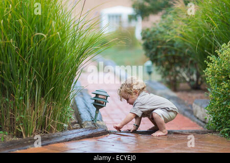 Caucasian baby boy playing on brick walkway Stock Photo