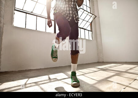 African American man dancing in loft Stock Photo