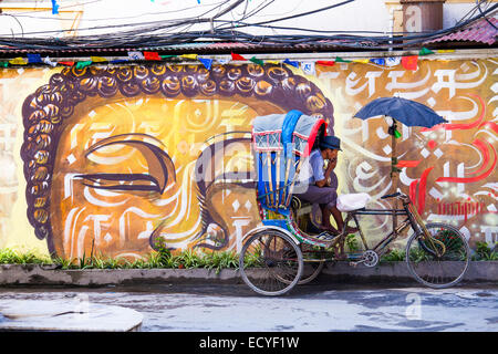 Cycle rickshaw in front of wall arta in Thamel, Kathmandu, Nepal Stock Photo