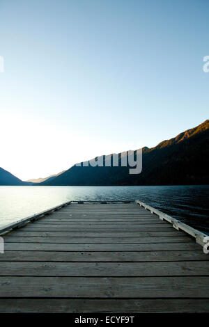 Wooden deck at lake under blue sky Stock Photo