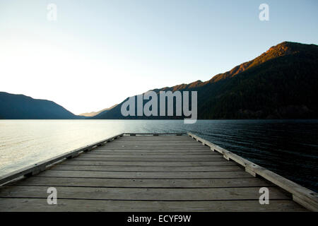 Wooden deck at lake under blue sky Stock Photo