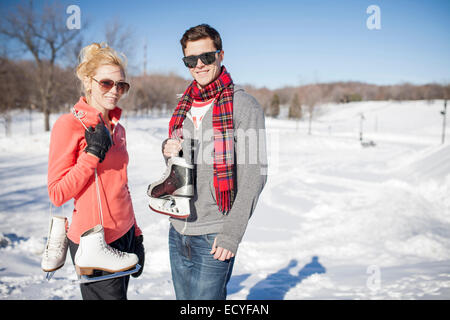Caucasian couple carrying ice skates in winter