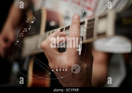 Caucasian man playing guitar overlaid with graphic design Stock Photo