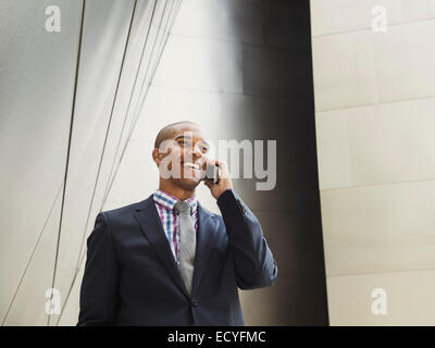 Low angle view of Black businessman talking on cell phone Stock Photo