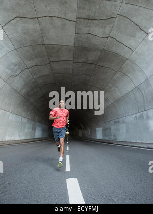 Black man running in urban tunnel Stock Photo