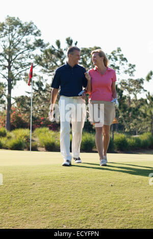 Caucasian couple playing golf on course Stock Photo