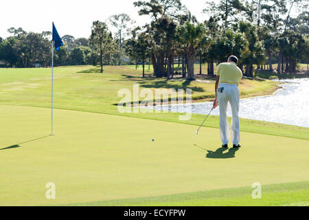 Caucasian man putting on golf course Stock Photo