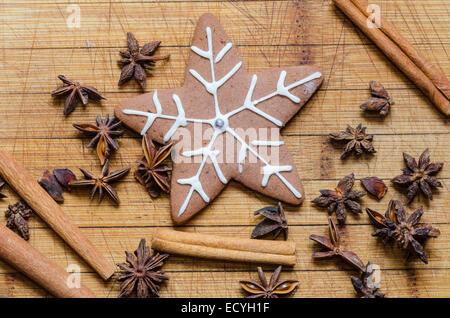 snowflake shaped gingerbread cookie with cinnamon sticks and anise Stock Photo