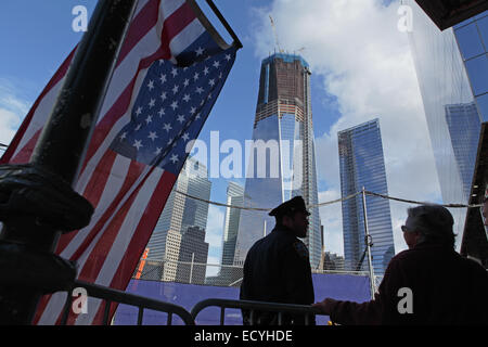 An American flag hangs over the sidewalk on Liberty Street in front of One World Trade Center at Ground Zero in New York Stock Photo