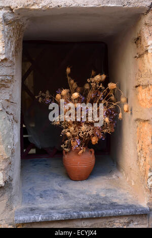 Dried flowers and vase in window in Mesta village, Chios Stock Photo