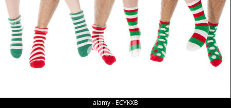 Many feet in Christmas socks isolated over white background Stock Photo