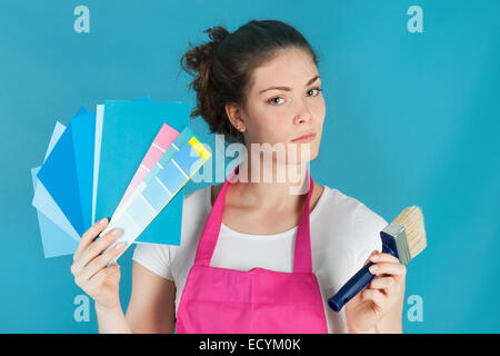 Woman with color samples against blue wall Stock Photo