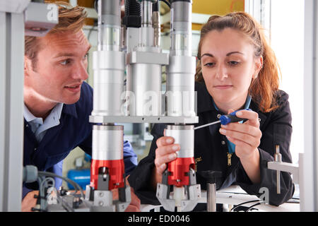 Engineer And Apprentice Working On Machine In Factory Stock Photo