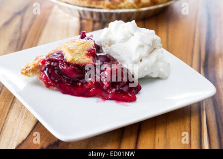 view form above of a fresh baked cherry pie with a slice on a white plate Stock Photo