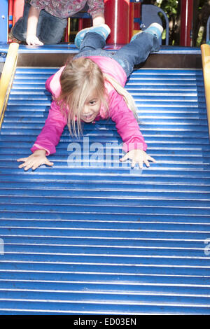 Child going down a rolly slide in a park. Stock Photo