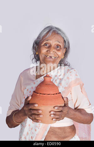 1 indian Old Senior Woman Saving money Piggy Bank Stock Photo