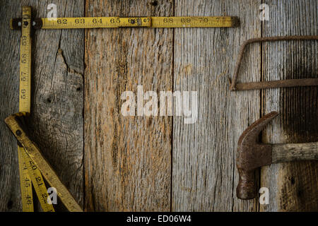 Measuring Tape Hammer and Saw on Rustic Old Wood Background Stock Photo