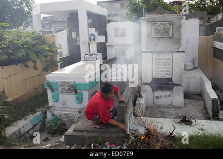 This cemetery in the heart of Pasay in Metro Manila, is the resting place for over 10,000 deceased people and some living ones. About ten cemetery caretakers and their families live there, in very poor conditions but still feeling safer among the graves than living on the outside as this poor neighbourhood is known for drugs and violence. They look after each other and fend of any squatters or intruders, especially males, to protect their children. 14th Dec, 2014. © Probal Rashid/ZUMA Wire/Alamy Live News Stock Photo