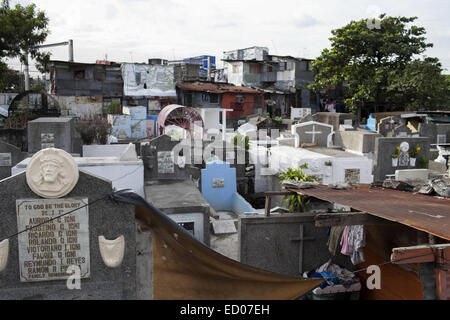 This cemetery in the heart of Pasay in Metro Manila, is the resting place for over 10,000 deceased people and some living ones. About ten cemetery caretakers and their families live there, in very poor conditions but still feeling safer among the graves than living on the outside as this poor neighbourhood is known for drugs and violence. They look after each other and fend of any squatters or intruders, especially males, to protect their children. 14th Dec, 2014. © Probal Rashid/ZUMA Wire/Alamy Live News Stock Photo