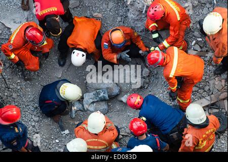 Beijing, Indonesia. 31st Oct, 2014. Rescuers gather around the body of a victim during an operation in Jakarta, Indonesia, Oct. 31, 2014. It is believed that an archive building collapsed on Friday morning, causing four construction workers dead, five workers seriously injured and two members of a rescue team slightly injured when searching victims. © Veri Sanovri/Xinhua/Alamy Live News Stock Photo