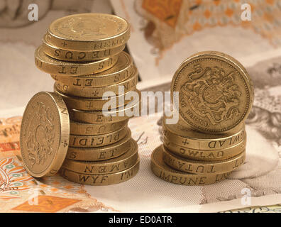 Pile of British one pound coins with background of £10 English banknotes Stock Photo