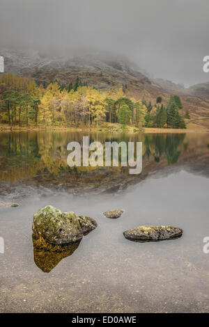 Autumn is reflected in the stunning Blea Tarn in the English Lake District. Stock Photo