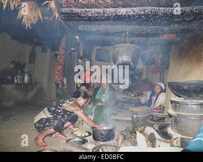 Family cooking dinner in their house in a mountain village, Nepal Stock Photo