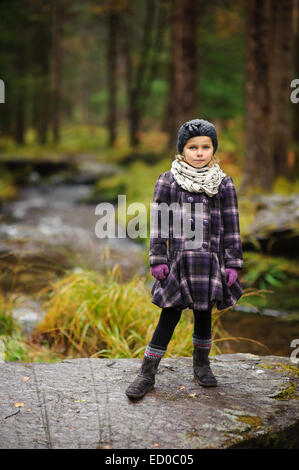 Young girl (2-3) out for autumn walk in forest. Stock Photo