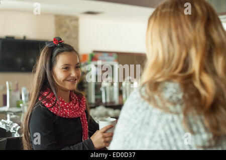 Little girl (6-7) drinking tea and smiling Stock Photo