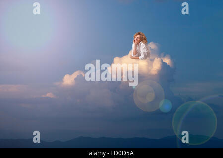 Blonde woman dreaming on cloud Stock Photo