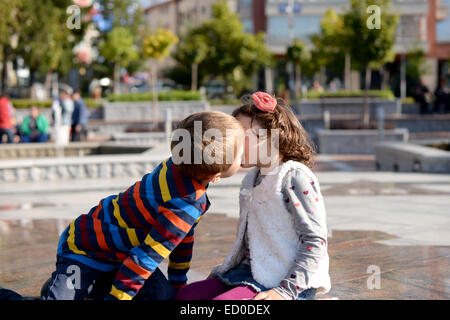 Little boy (6-7) and girl (4-5) kissing Stock Photo