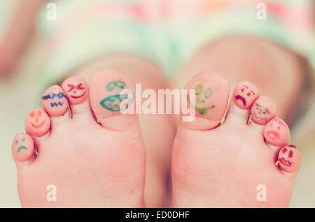 Girls feet with smiley face drawings Stock Photo