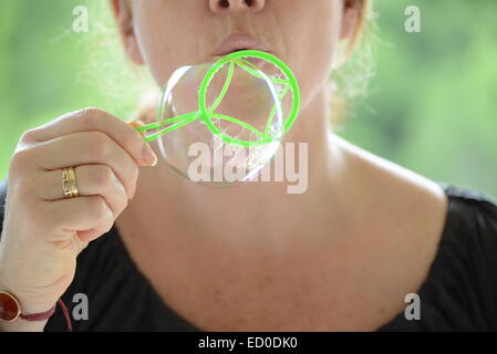 Woman blowing bubbles Stock Photo