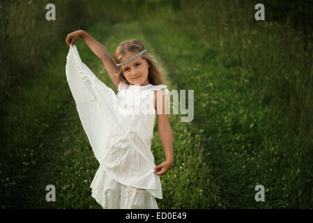 Young girl (4-5) posing in long white dress