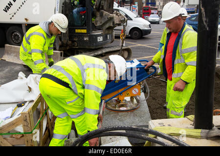 LONDON - OCTOBER 15TH: Unidentified workman using a sprobst vacuum stone magnet by Turnpike lane station on October 15th, 2014 i Stock Photo