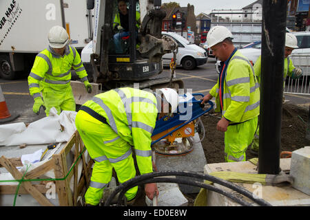 LONDON - OCTOBER 15TH: Unidentified workman using a sprobst vacuum stone magnet by Turnpike lane station on October 15th, 2014 i Stock Photo