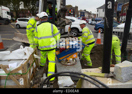 LONDON - OCTOBER 15TH: Unidentified workman using a sprobst vacuum stone magnet by Turnpike lane station on October 15th, 2014 i Stock Photo