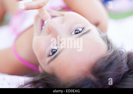 Close-up portrait of a smiling girl sucking her thumb Stock Photo