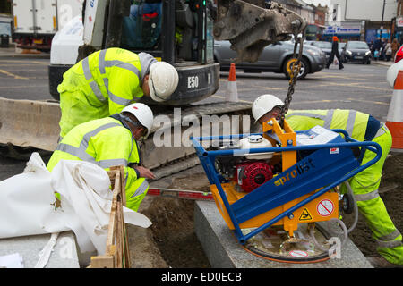 LONDON - OCTOBER 15TH: Unidentified workman using a sprobst vacuum stone magnet by Turnpike lane station on October 15th, 2014 i Stock Photo