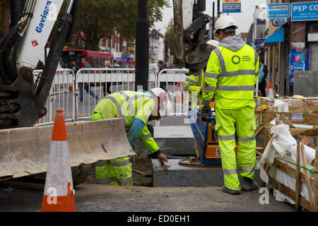 LONDON - OCTOBER 15TH: Unidentified workman using a sprobst vacuum stone magnet by Turnpike lane station on October 15th, 2014 i Stock Photo