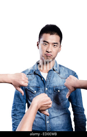 Young man being disliked by thumbs down Stock Photo